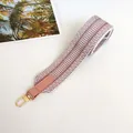 Close-up of pink and white woven shoulder strap with leather end and gold metal hook - Pink Style 2 with Pink Trim