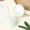 Portable mint green folding hairbrush with round mirror in a compact travel design - Light Green