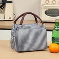 Blue and white striped lunch bag with brown handles on a kitchen counter - Navy Stripe