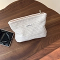 Dettaglio della pochette jacquard crema con etichetta Simple Wish su base in legno - Trama di spiga di riso / crema