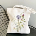 White canvas tote bag featuring watercolor floral prints on a black metal mesh chair - Watercolor Floral Botany (STD344-F)
