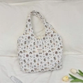 Detail of white quilted tote bag with colorful cartoon puppy patterns and fabric brand label - Cartoon Dog