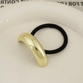 Minimalist gold curved metal hair tie with black elastic band on white plate - Single Layer Arc Gold