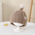 Dettaglio del cappello in maglia marrone per neonati con pompon bianco su base - 2-5 Anni / Cachi