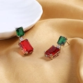 Close-up of emerald and ruby rectangle crystals on luxurious gold silk fabric - Green + Red