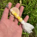 Détail d'un porte-clés perles HBD, avec disque en bois et pompon blanc élégant - Jaune HBD Lettre