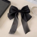 Detailed close-up of large black organza ribbon bow hair clip with elegant long streamers - Black
