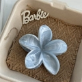 Close-up of a blue marble texture flower hair claw clip inside a gift box on burlap - Blue