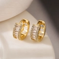 Macro detail of gold plated hoop earrings with rectangular and round cubic zirconia - Gold