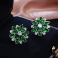 Macro shot of luxury emerald green sunflower earrings with white cubic zirconia accents - Green