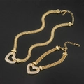 Gros plan du pendentif cœur doré avec cristaux sur une élégante chaîne double - Bracelet en or