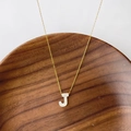 Collier doré avec pendentif lettre 'J' en nacre blanche au design minimaliste chic - Lettre J