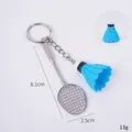 Mini badmintonracket en blauwe shuttle sleutelhanger met afmetingen op witte achtergrond - Blauwe Shuttle + Racket