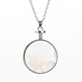 Detail of round glass pendant filled with natural pink crystal stones on silver chain - Silver + Rose Quartz