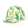 Close-up of baseball cap featuring tropical banana and green leaf print on white fabric - White Banana Leaf