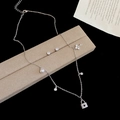 Dettaglio di un set di gioielli in argento con lucchetto a trifoglio, chiave e perle - Argento