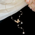 Detailed view of butterfly pendant pearl necklace with sparkling rhinestones on black background - Gold (18K Gold Plated)