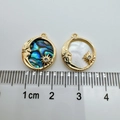 Close-up of 18K gold celestial pendants with abalone shell and mother of pearl details - 1 Piece / Gold Sun Moon Star White Shell