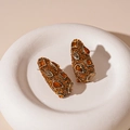 Detailed view of vintage amber diamond earrings with geometric rhinestones and warm tones - Champagne