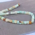 Close-up of square natural stone beads with colorful textures and cube cut for jewelry DIY - Amazonite