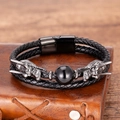 Detail of black double-layered leather bracelet with silver dragon heads on a notebook - Dragon Head Black Agate