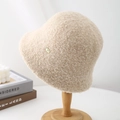 Minimalist beige lamb wool bucket hat for women presented on a wooden display stand - Beige