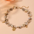 Detailed view of beach necklace with natural shell beads and gold sea life charms - Conch Necklace