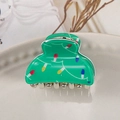 Macro detail of green acrylic hair clip featuring festive string light patterns and metal teeth - Green Christmas Tree Lights