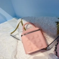 Pink jelly mini bucket bag with metallic studs and chain strap on plush background - Light Pink