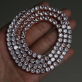 Hand holding a 5mm rose gold tennis chain necklace with clear sparkling cubic zirconia - Rose Gold 41cm