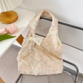Detail of floral embroidery and white lace bow decoration on cream tote bag - Green + Apricot Flower