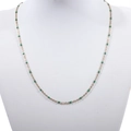 Detail of a thin gold beaded necklace with vibrant green enamel beads on a jewelry bust - Gold + Dark Green