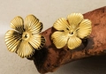 Elegant gold flower stud earrings with detailed petal texture on rustic wooden display - Gold 3D Radial Texture Floral