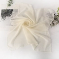 Cream white square chiffon scarf in soft spiral fold on a clean aesthetic background - Beige