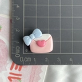 Detailed scale view of a pink resin envelope charm with blue bow for DIY crafts - Envelope