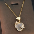 Detail of gold heart pendant necklace featuring moonstone center and zircon star accents - Gold - Frosted Heart