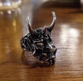 Macro detail of silver Hannya demon mask ring with horns and fangs on wooden surface - Silver Horn Ring
