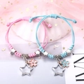 Geflochtene Paar-Armbänder in Rosa und Blau mit Stern- und Kirschblütenanhängern - Blütenblatt und Stern (2er-Set - Buntes Seil)