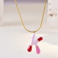 Detailed macro view of the gold-plated chain with pink and red enamel letter K pendant - Letter K