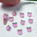 Vue macro de breloques à ongles en forme de pêche en résine avec paillettes et feuilles - 01 Pêche