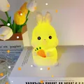 Cute bunny night light holding a carrot with warm glow on a stack of books - Rabbit with Carrot