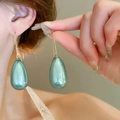 Close-up of model wearing water-drop pearl earrings in a vibrant teal glazed finish - Teal Pearl Glossy Waterdrop (89# Hook)