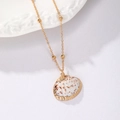 Golden beaded chain necklace featuring a natural style shell pendant on white textile - Gold Chain-Natural Conch