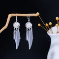 Macro detail of silver feather earrings hanging on a branch with flower vase accent - Fine Engraved Feather Shape Style (E5391)