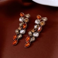 Primer plano de pendientes vintage dorados con cristales naranjas y claros sobre tela - Poste de plata para pendientes-Dorado-Café
