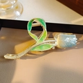 Elegant tulip claw clip with green leaf detail and blue flower on beige leather stand - French Vintage Tulip Shape Claw