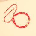 Detail of red beaded evil eye bracelet with adjustable cord and golden accents - Red