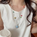 Gros plan d'un collier de perles coloré avec breloques papillon et champignon sur un modèle - Corde Bleue Champignon Papillon Fermoir OT (12#)