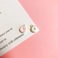Detailed view of donut pendants in plain silver and pink enamel on a pink background - 9# Peach Doughnut Matte Silver