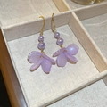 Détail de boucles d'oreilles pétales de fleurs violettes avec crochets dorés sur lin - Crochet d'oreille pétale en acrylique violet